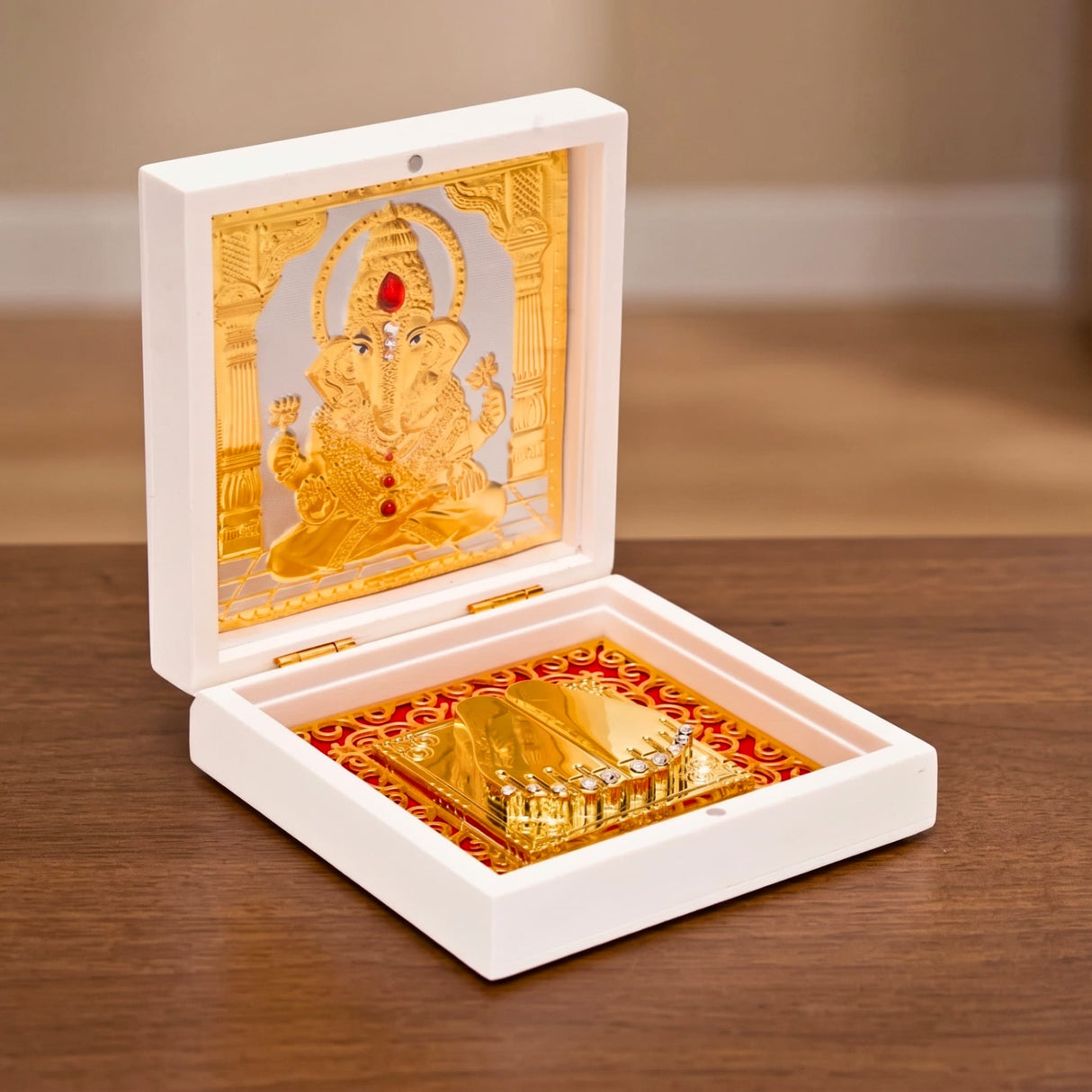 Gold plated laxmi ganesha idol with red gemstone accents in ornate white box with red and gold fabric for pooja decor