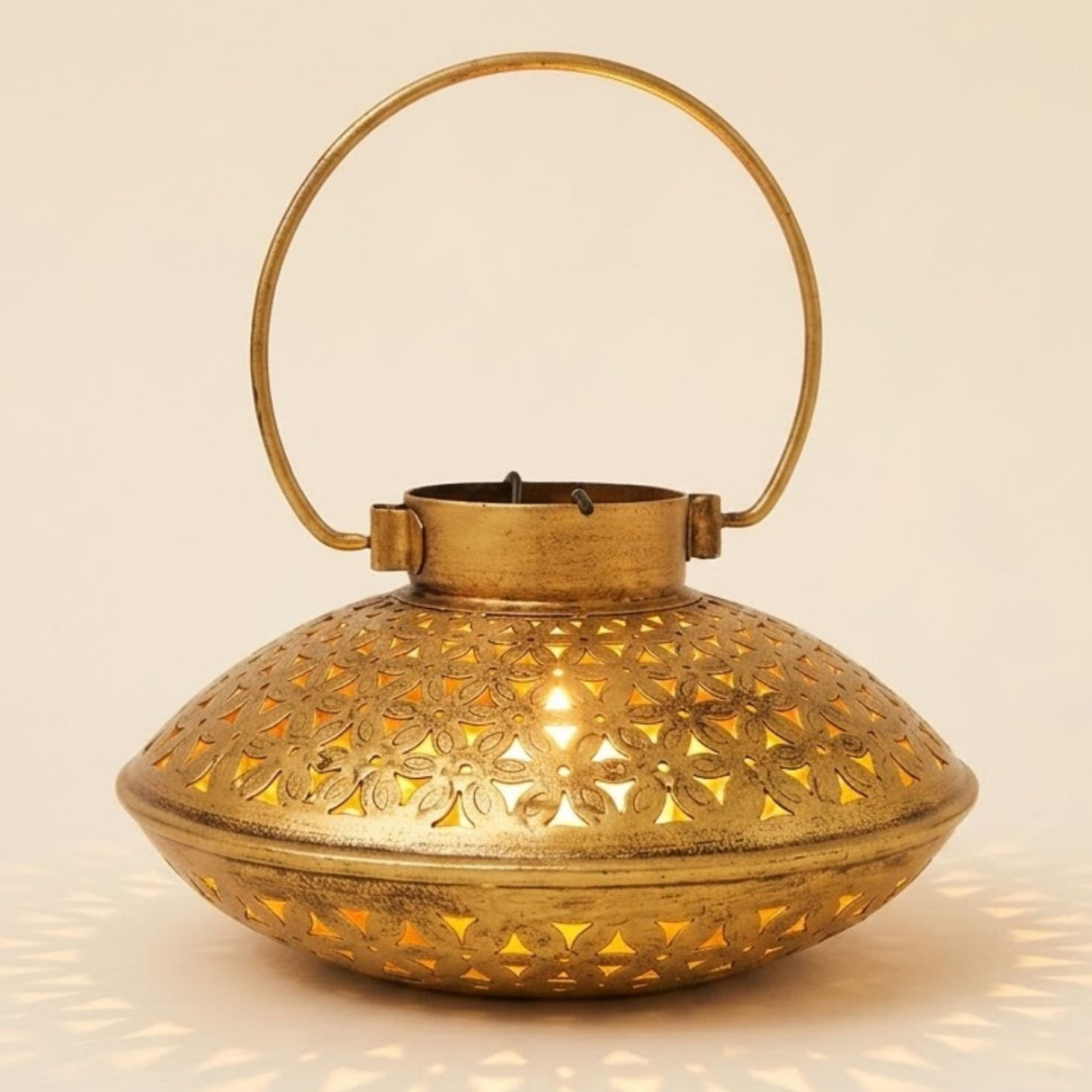 Golden brass tealight candle stand with intricate floral cutouts and circular handle antique style incense holder