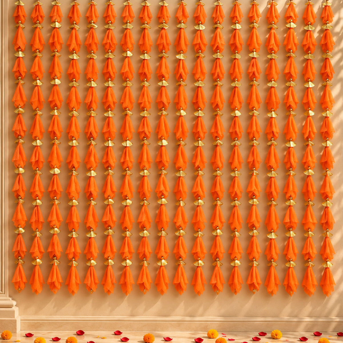 Orange tassels with gold decorative caps hanging in neat vertical rows on gotta patti net backdrop for diwali eid wedding decor