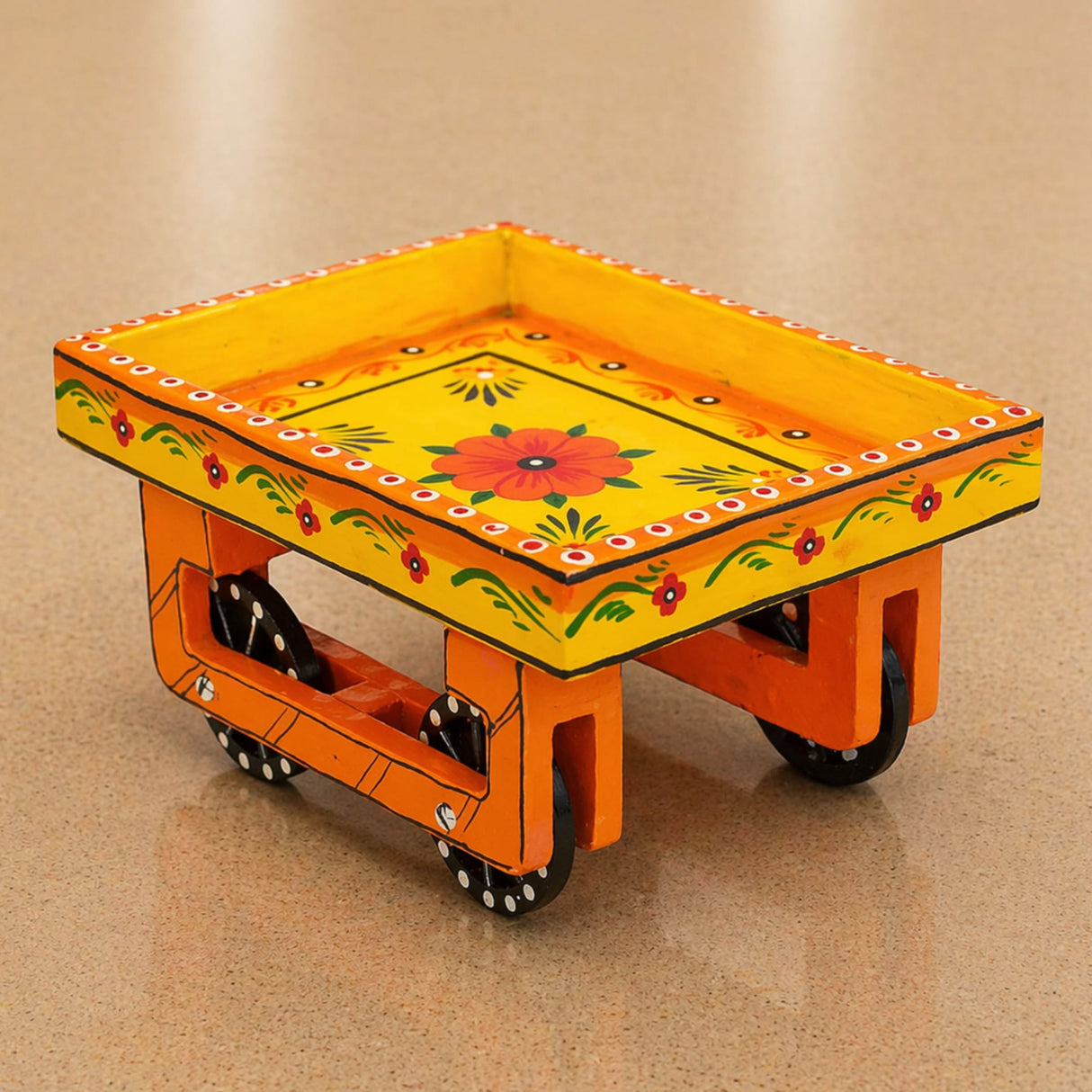 Vibrant yellow and orange hand-painted wooden trolley with black wheels and floral designs for serving snacks and tea