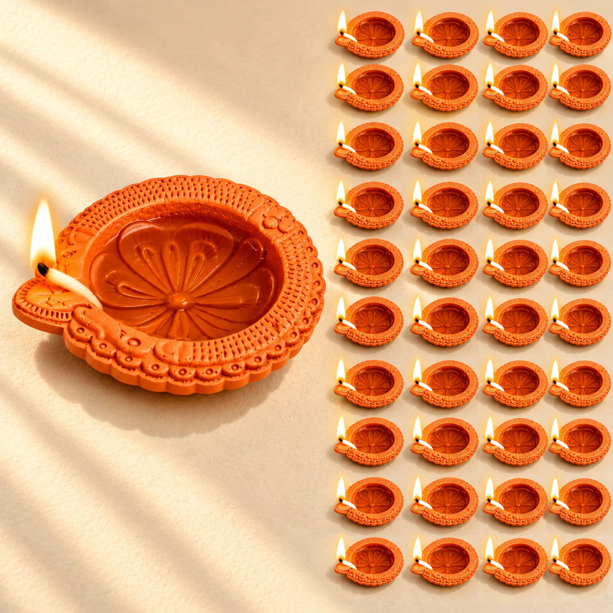 Handmade orange terracotta clay diya with intricate floral embossing and lit wick for pooja and Diwali decoration