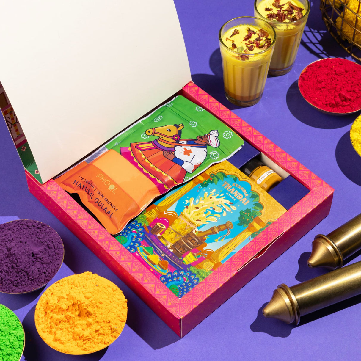 Premium Holi gift box with vibrant pink packaging, natural gulab jamun, gulal colors, thandai mix, chandan tika, and greeting card