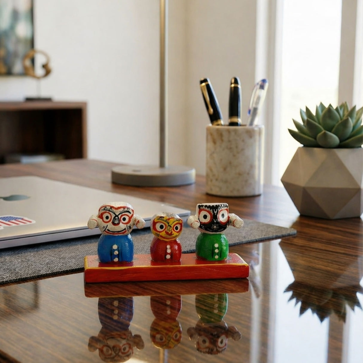 Three colorful wooden lord jagannath balabhadra subhadra dolls with painted faces on a red base for home decor and puja