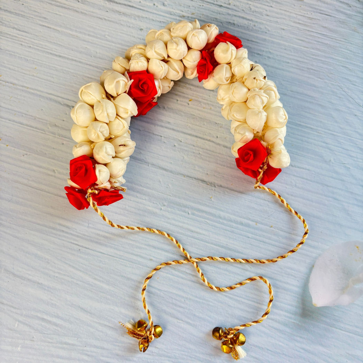 Traditional artificial jasmine gajra cream and red floral headpiece with small bells and twisted gold cord for bridal hair
