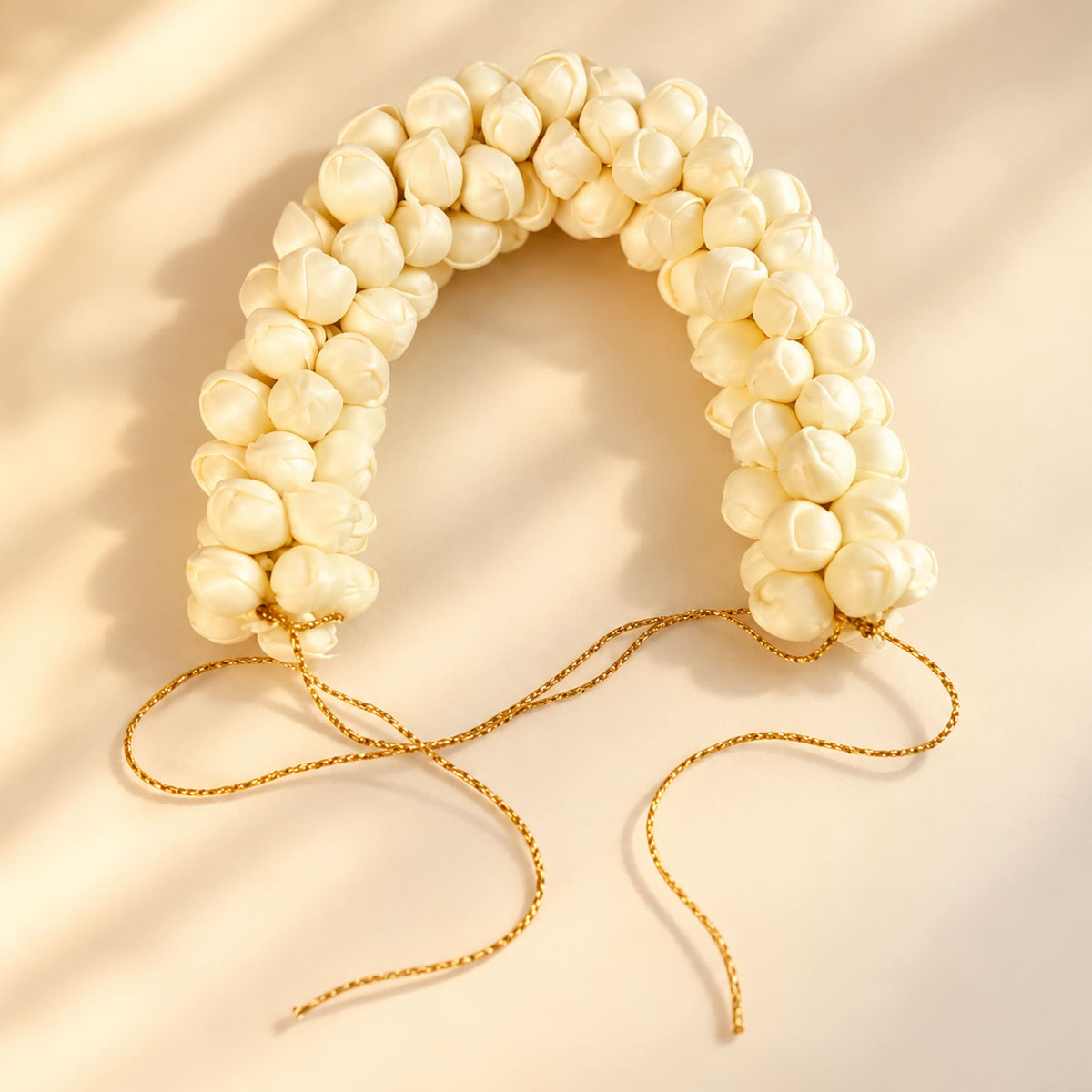 Traditional artificial jasmine gajra with cream pearl-like beads and gold cord ties for bridal mehndi and weddings
