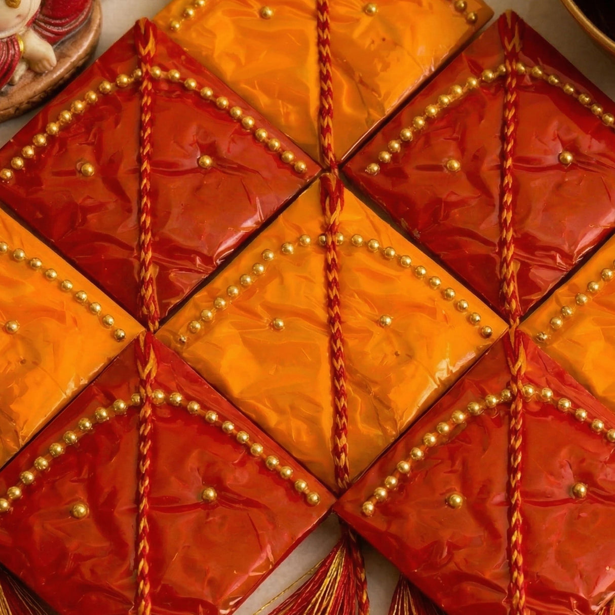 Vibrant red and orange haldi kumkum packets with gold beads and braided cords for indian wedding and festive essentials