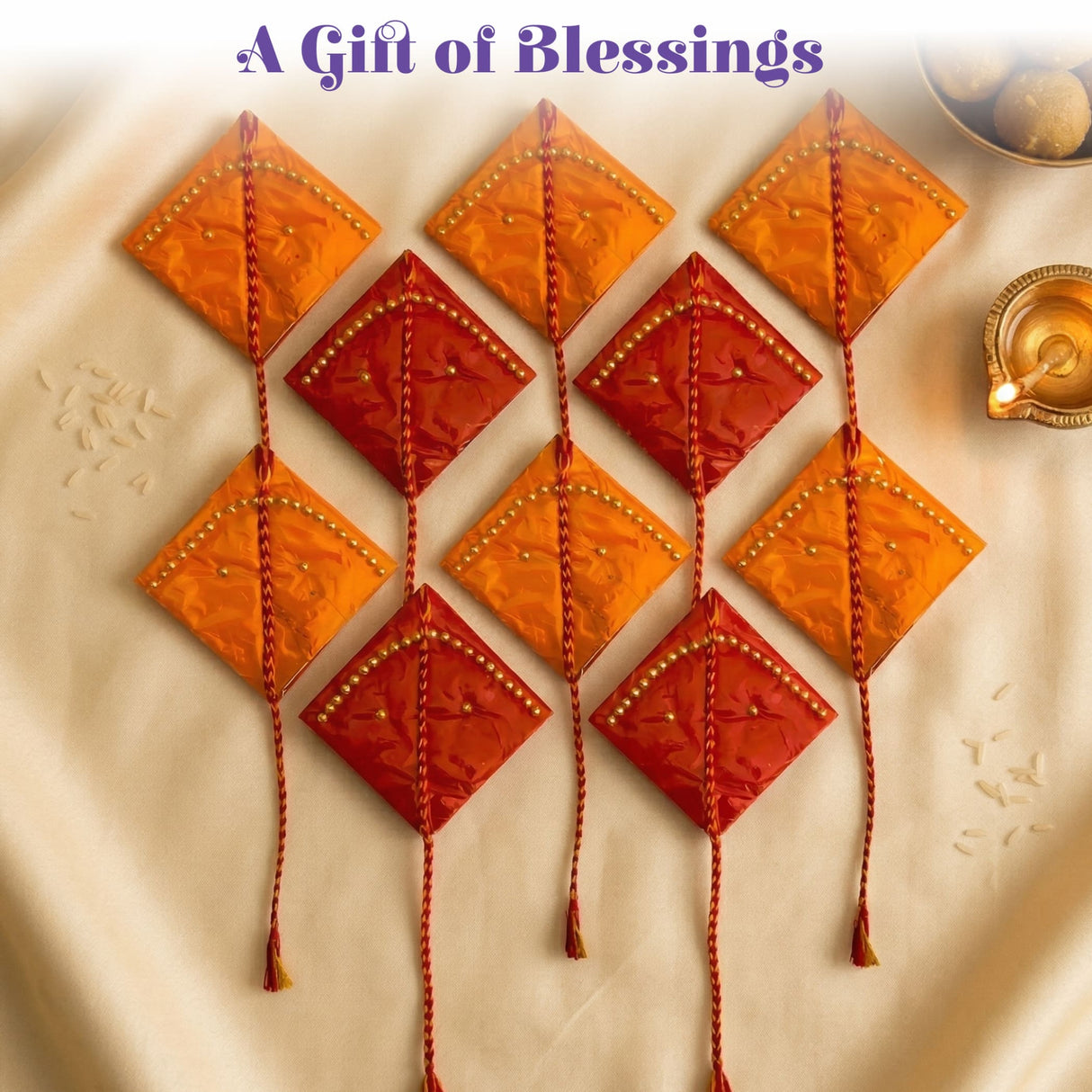 Vibrant orange and red diamond-shaped haldi kumkum packets with beaded edges and braided tassels for indian wedding and puja