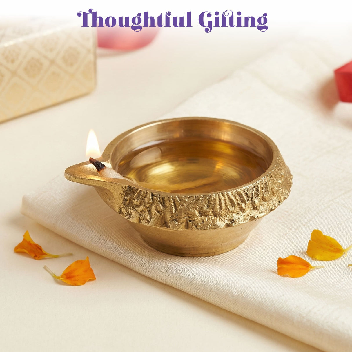 Golden brass kuber diya with intricate textured rim and lit wick for diwali puja traditional indian oil lamp decor