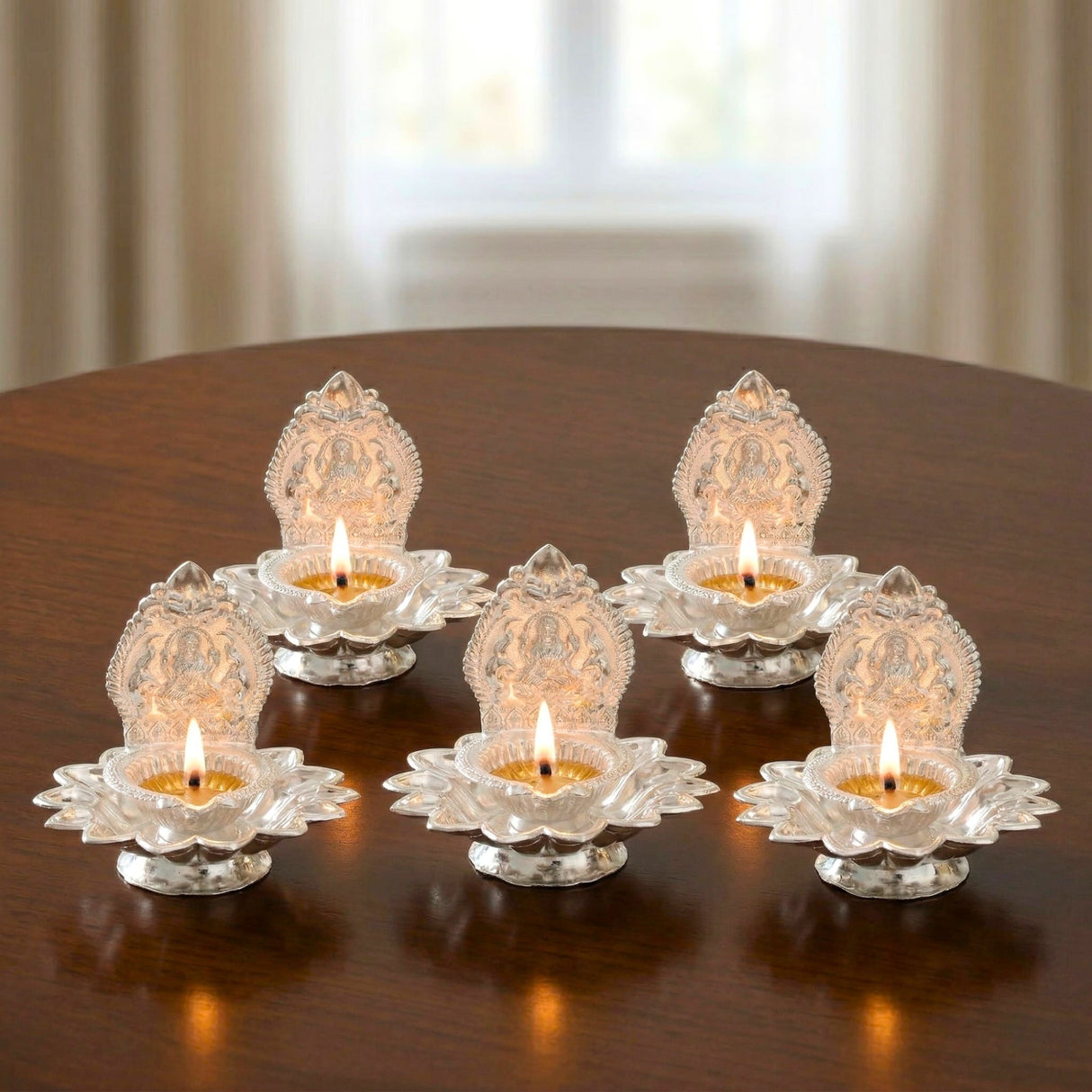 Lakshmi silver plated diya oil lamps with intricate lotus engraving and burning wicks for Diwali puja decor