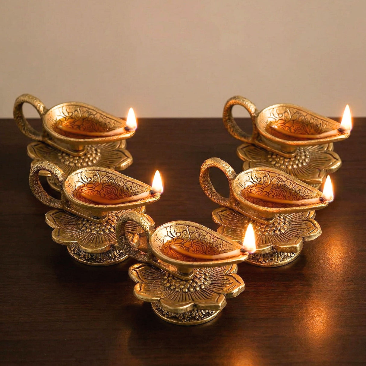 Golden brass lotus finish diya oil lamps with intricate floral engravings and lit candles for home pooja and diwali decor