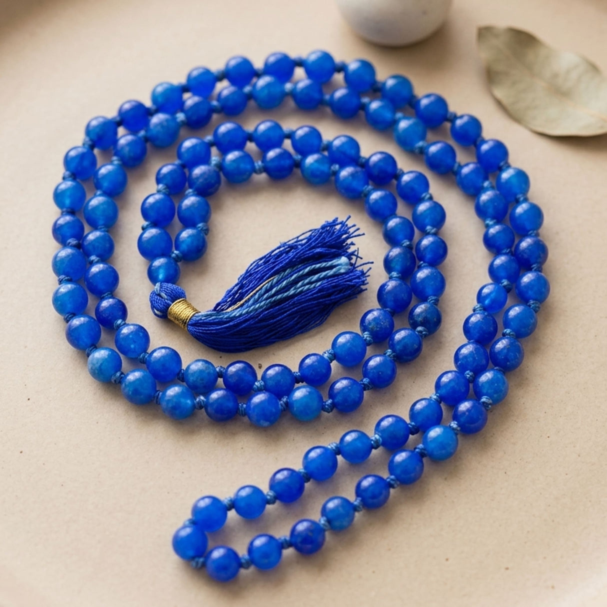 A vibrant royal blue LOVENSPIRE 108 mala beads necklace with natural healing crystals gold accents and matching tassel