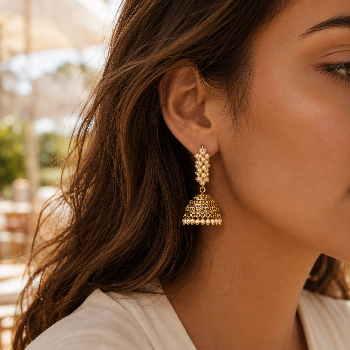 Gold-colored indian bali jhumka earrings with intricate filigree and pearl row for diwali wedding and ethnic wear