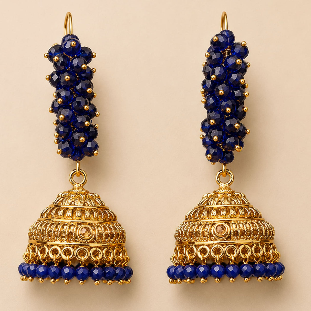 Elegant gold tone Indian Bali jhumka earrings with deep blue faceted beads and intricate filigree for ethnic wear