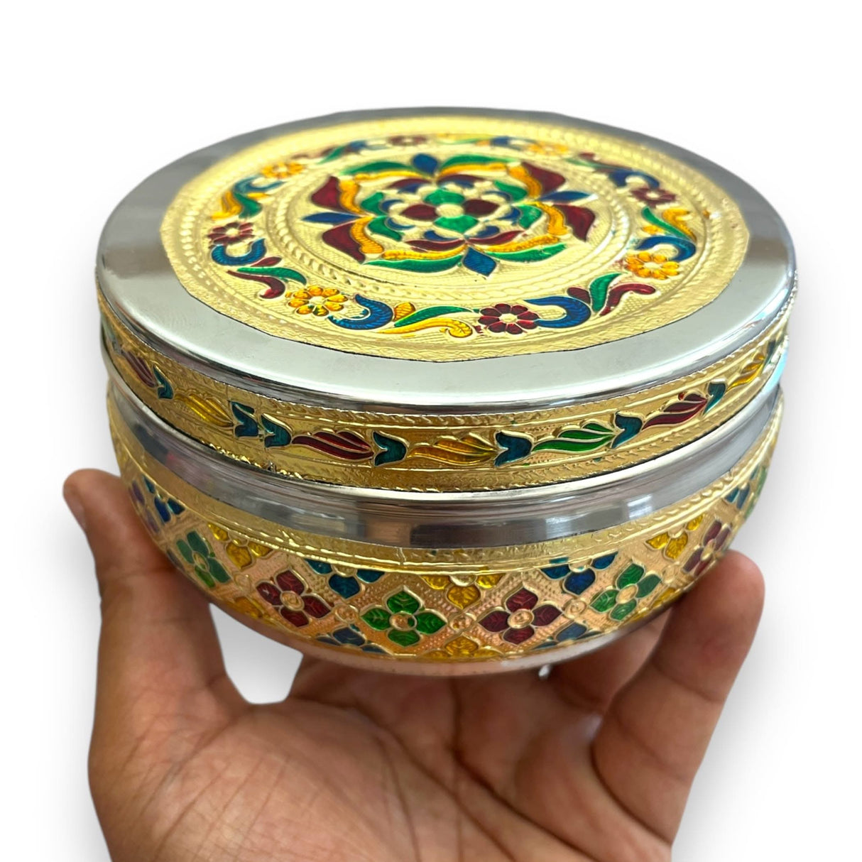 Ornate round metal container used as a decorative storage box for sweets and gifts