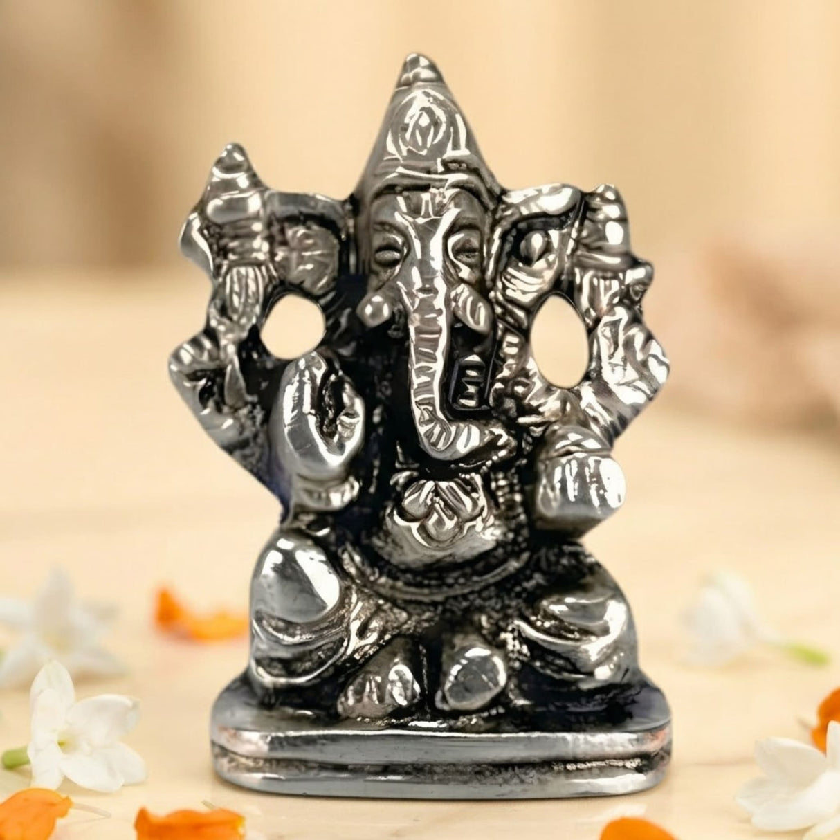 Silver-colored metal ganesha idol with intricate details and polished finish for car dashboard and home decoration