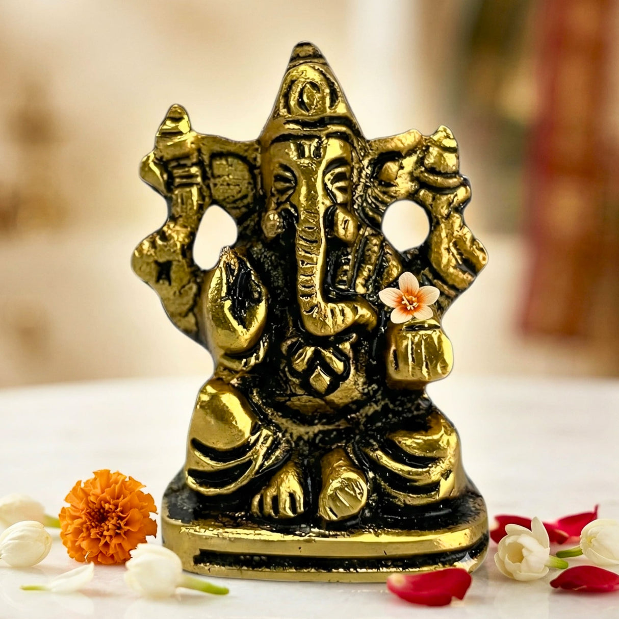 Golden brass lord ganesha car idol with intricate detailing and white flower for home decoration and pooja