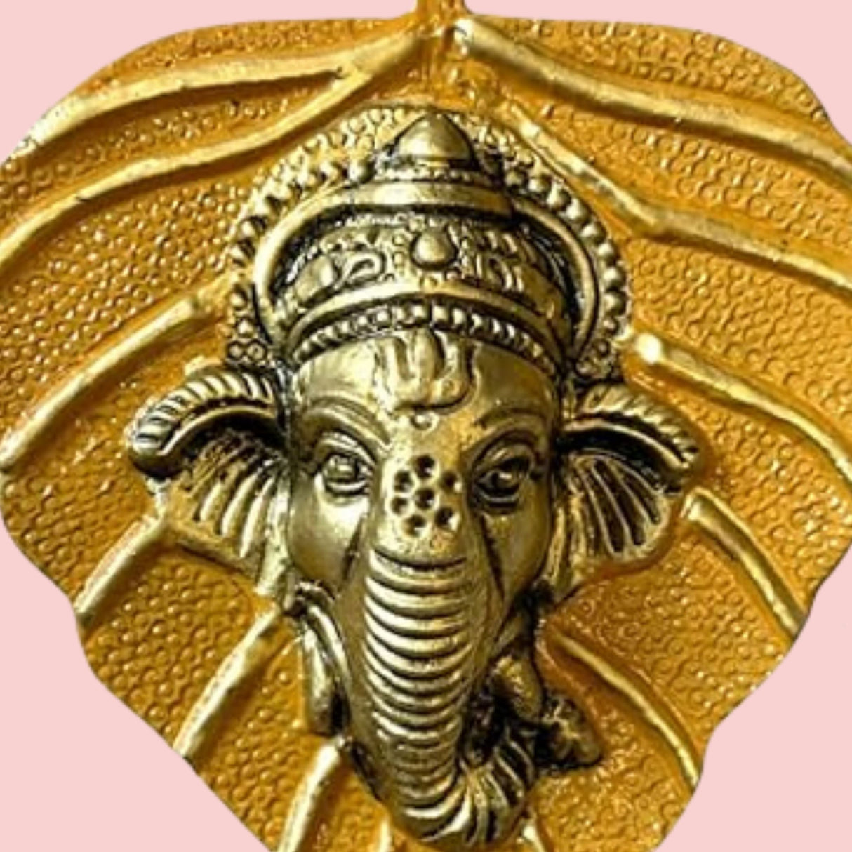 Golden metallic Ganesha pendant on textured leaf background, Diwali wall hanging