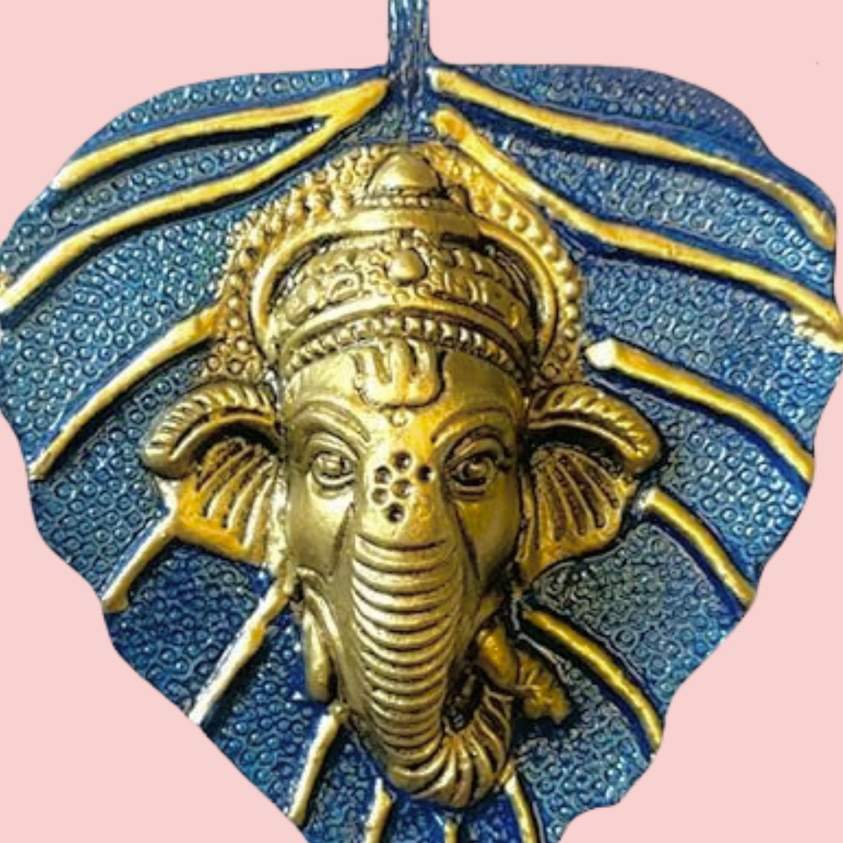 Golden Ganesha metal leaf wall hanging pendant on blue textured background