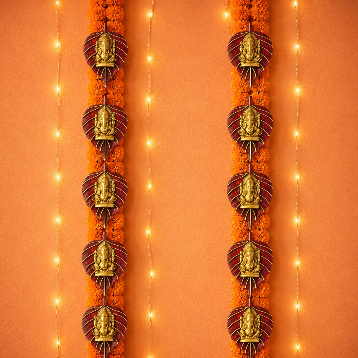 2 pcs metal leaf ganesha wall hanging with golden ganesha ornaments and maroon bases on orange marigold garlands for decor