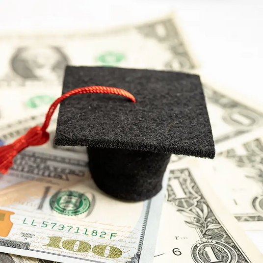Miniature graduation cap with a red tassel.