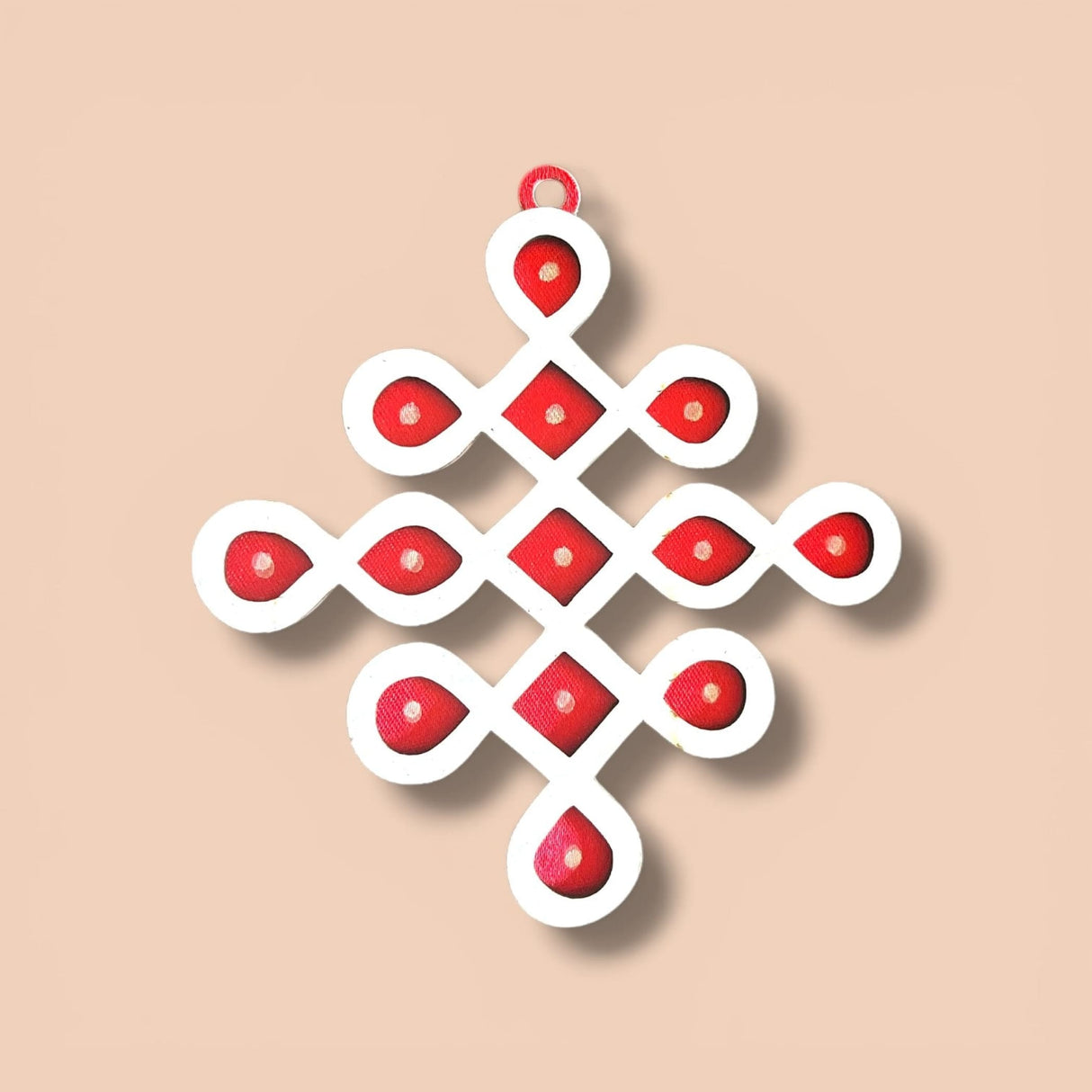 White and red geometric diy small muggu kolam cutout with symmetrical knot and circular accents for indian pooja decor