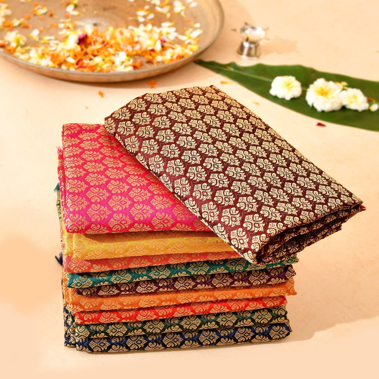 Stack of vibrant multicolor silk unstitched blouse pieces in pink gold and brown for saree pooja and indian return gifts