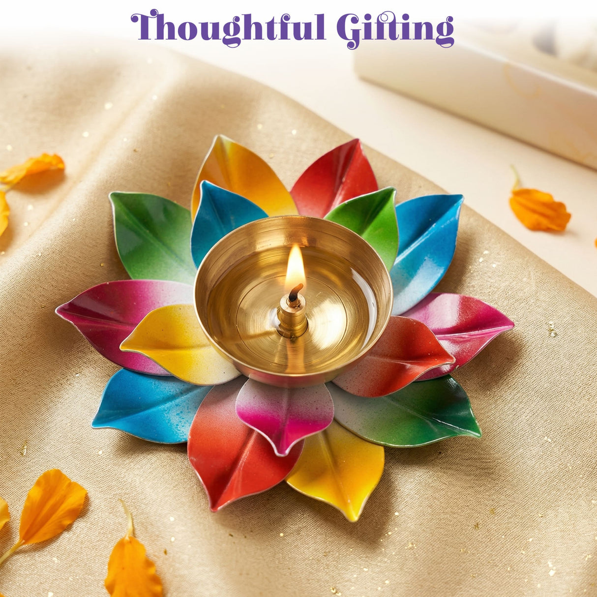 A vibrant multicolor lotus brass diya with a golden center holding a lit candle for puja and diwali decoration
