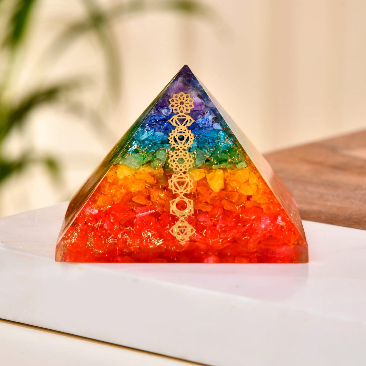 Rainbow-colored crystal pyramid with chakra symbols for healing and spiritual meditation