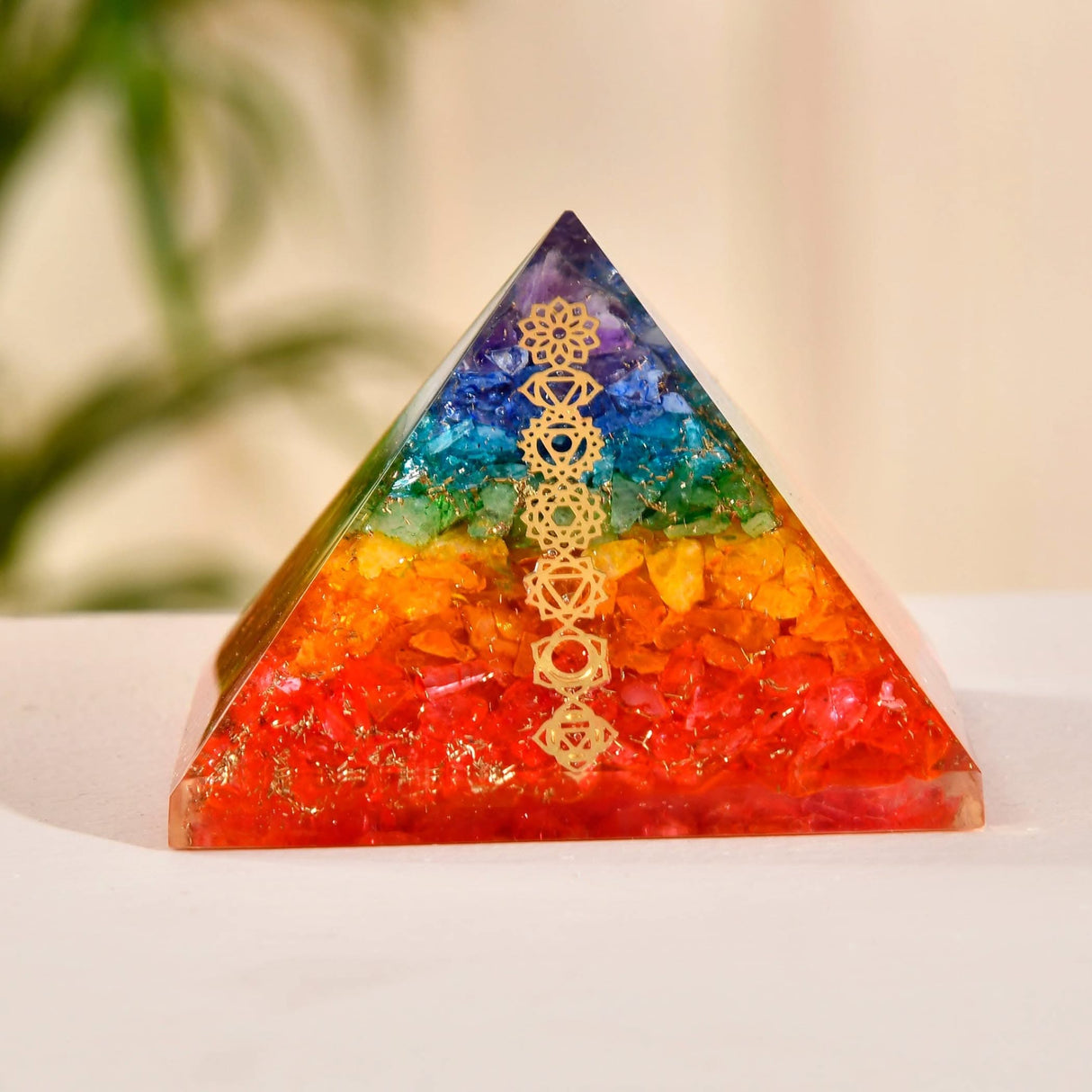 Rainbow-colored crystal pyramid with chakra symbols for healing and spiritual energy