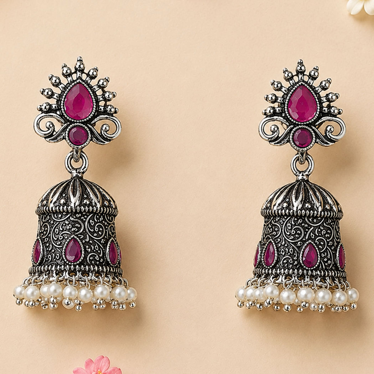 Silver oxidized floral jhumka earrings with intricate filigree, fuchsia gemstones, and white faux pearls for ethnic wear