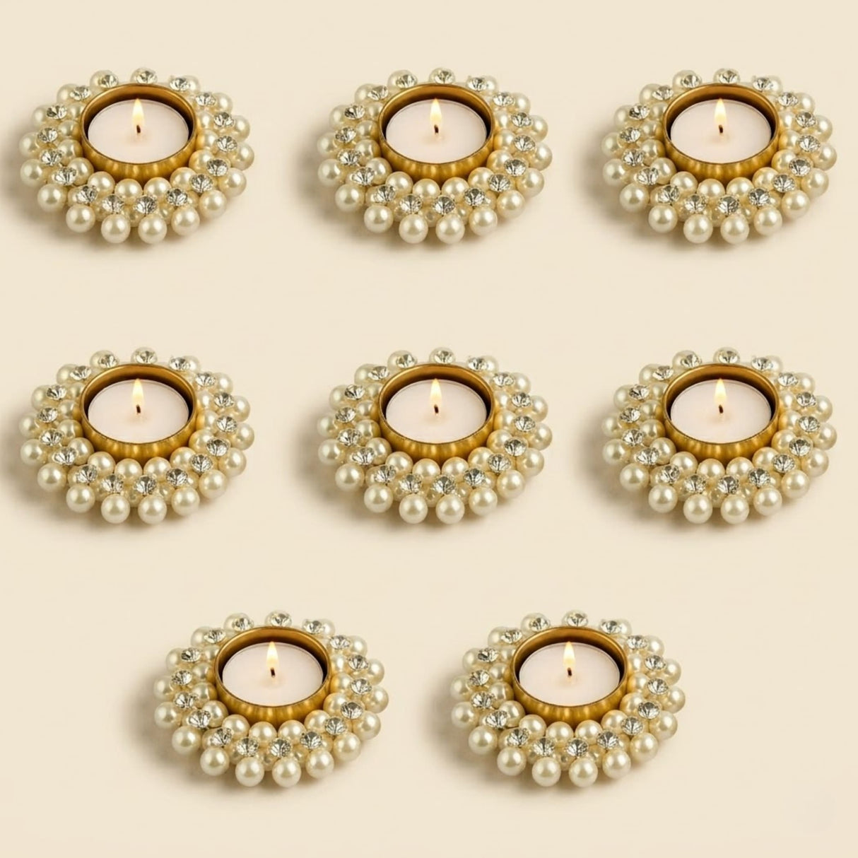 Elegant pearl and crystal-adorned gold-toned tealight holders with flickering candles for festive home decor