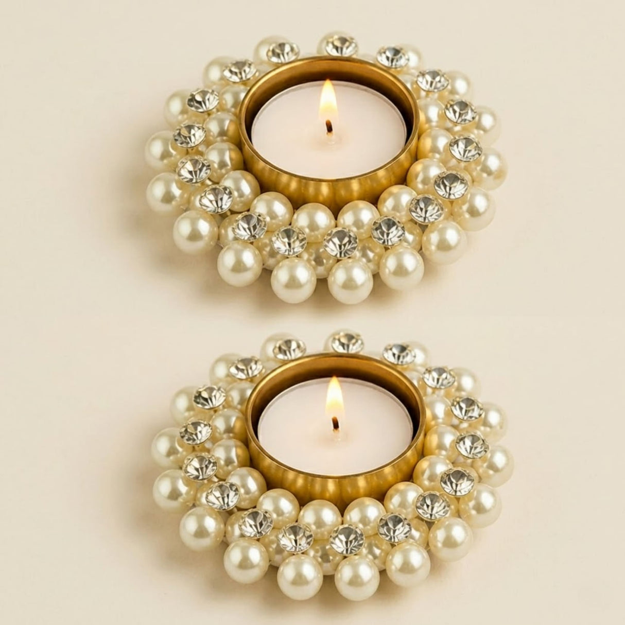Gold-toned tea light candle holder adorned with white pearls and clear rhinestones for festive home decor