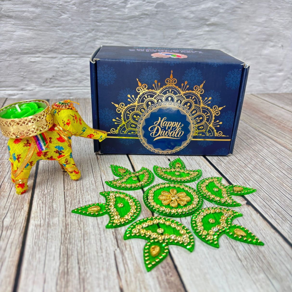 Decorative Diwali gift set with yellow elephant figurine, green tea light, and festive decorations