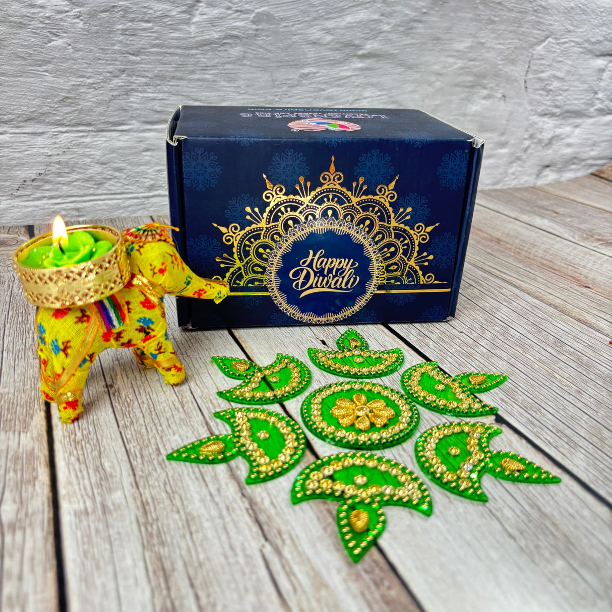 Vibrant yellow elephant-shaped candle holder with green tea light, festive Rangoli and Diwali gift box