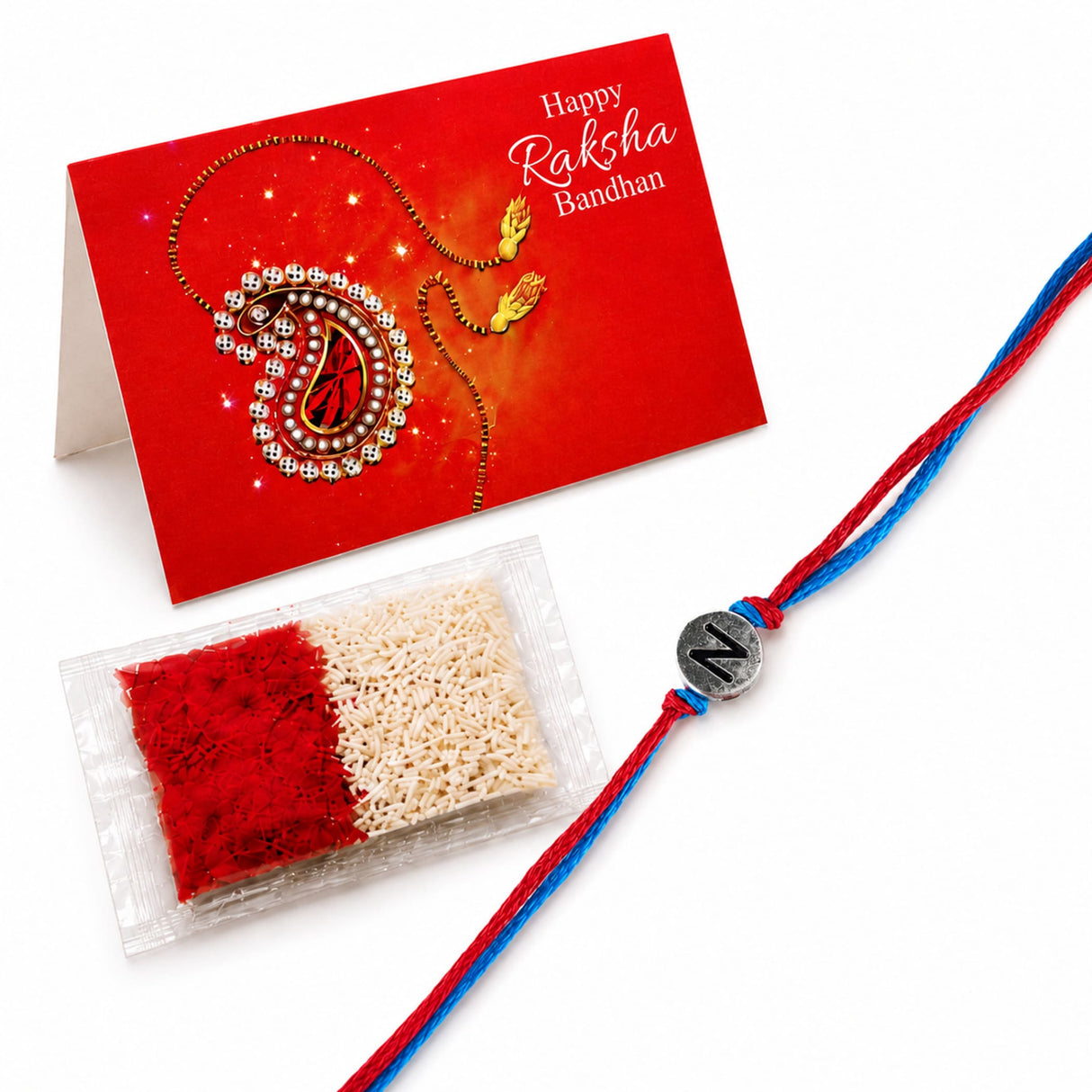 Designer custom single letter rakhi for brother and bhabhi featuring a red and blue braided thread with a silver n charm