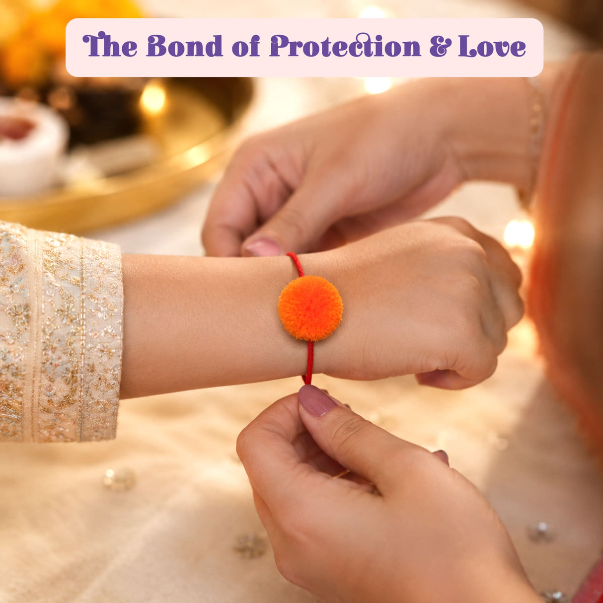 A bright orange pom-pom adorns a red string handmade designer pompom rakhi for Krishna and temple decoration