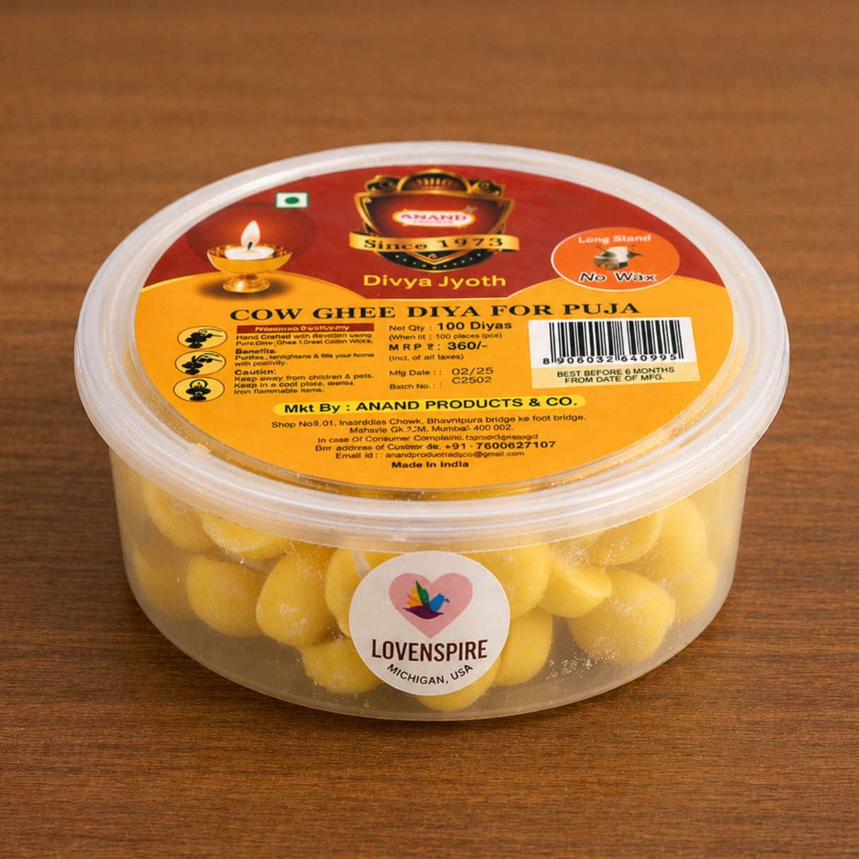 A clear plastic container of yellow cow ghee diyas labeled divya jyoth by anand products for pooja use