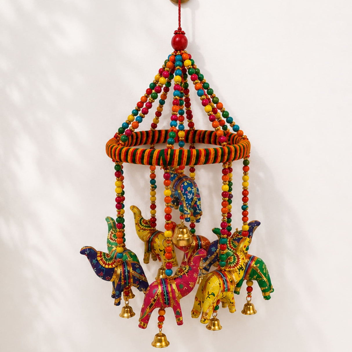 A vibrant handcrafted rajasthani ring elephant wall hanging with painted wooden elephants and golden bells for decor