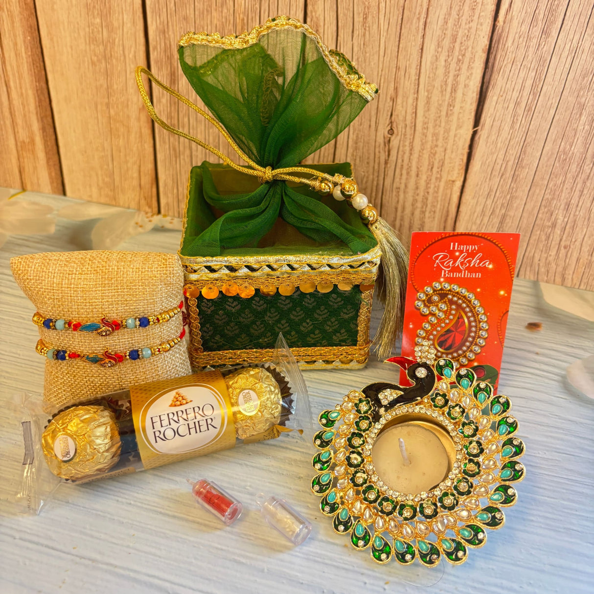 Gold and green peacock-shaped tealight holder with intricate detailing in ganesha raksha bandhan gift hamper for brother and bhabhi