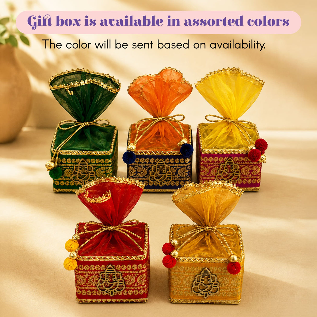 Assorted vibrant square gift boxes with golden ganesha embroidery and organza bows in raksha bandhan premium gift hamper