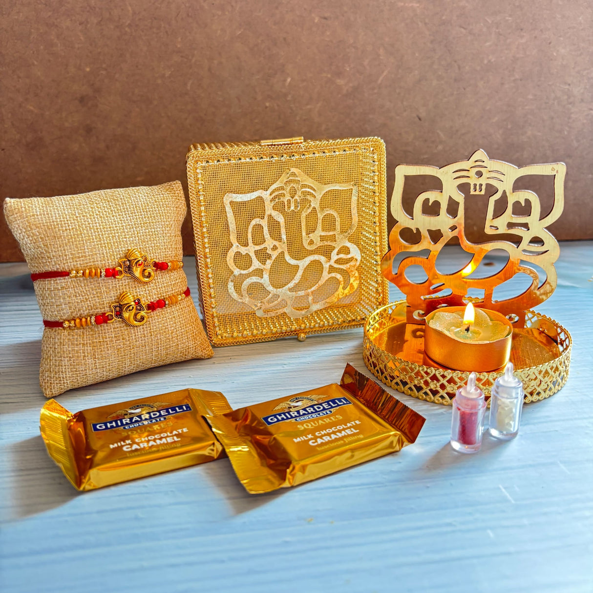 Gold-colored decorative box with intricate ganesha design etched on surface in ganesha raksha bandhan gift hamper set