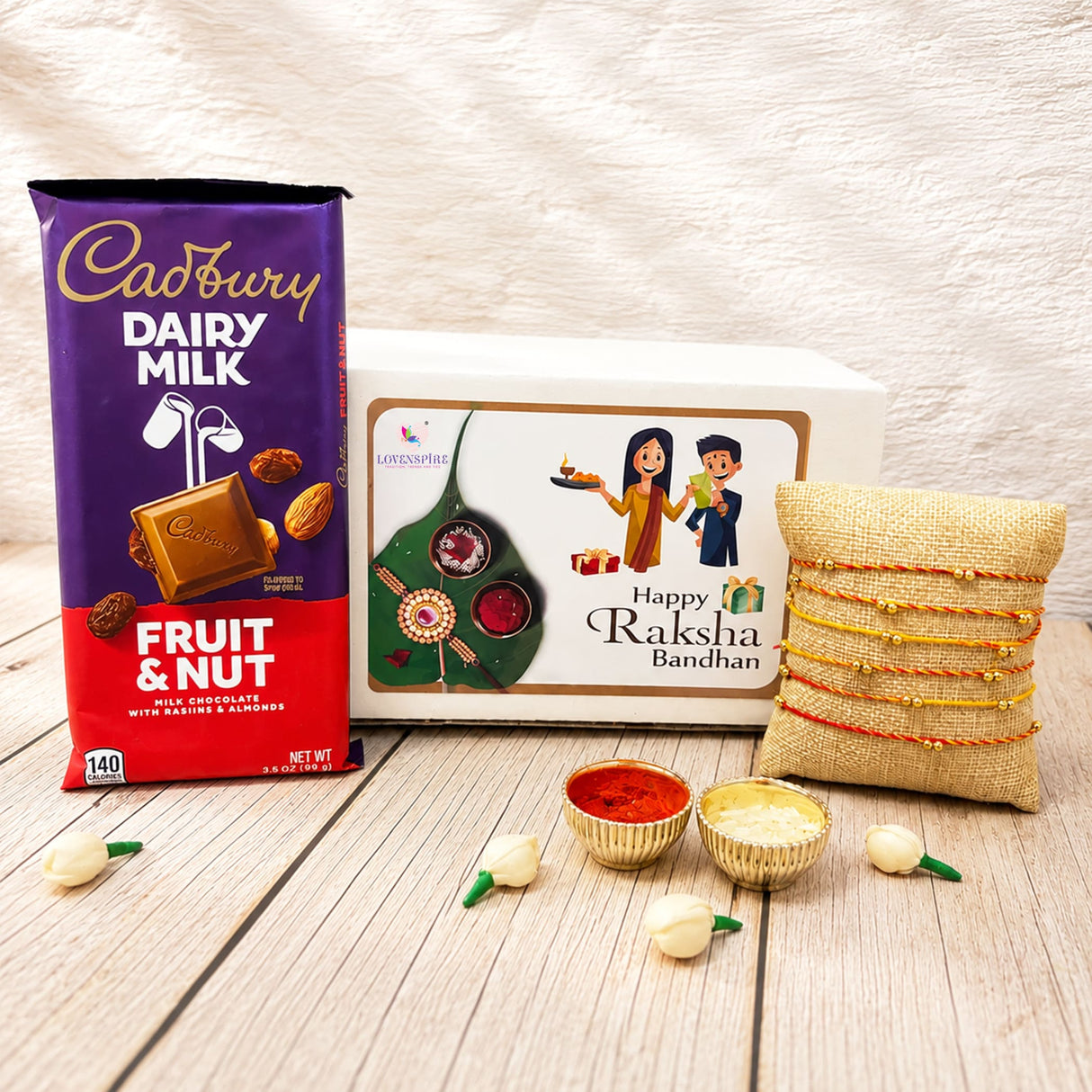 Purple and red cadbury dairy milk fruit and nut chocolate bar with golden logo in rakhi gift hamper for brother and bhabhi
