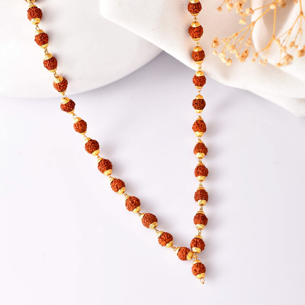 Rudraksha bead necklace with elegant gold accents for Raksha Bandhan gifting display
