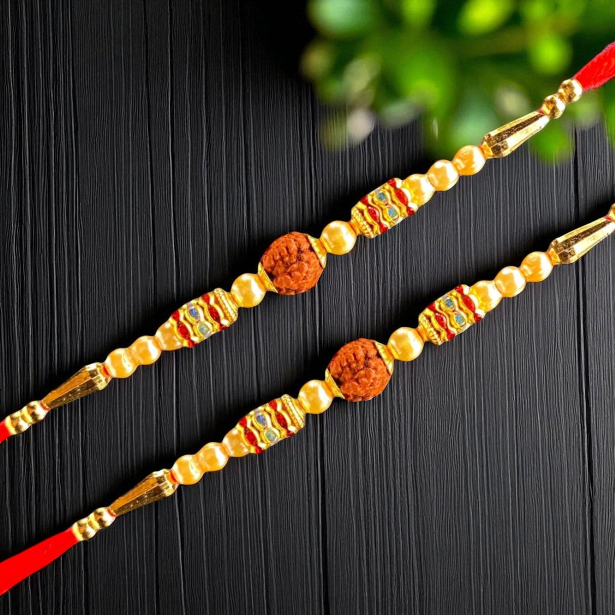 Two ornate Rakhi bracelets displayed in a Raksha Bandhan gift set with decorative accessories