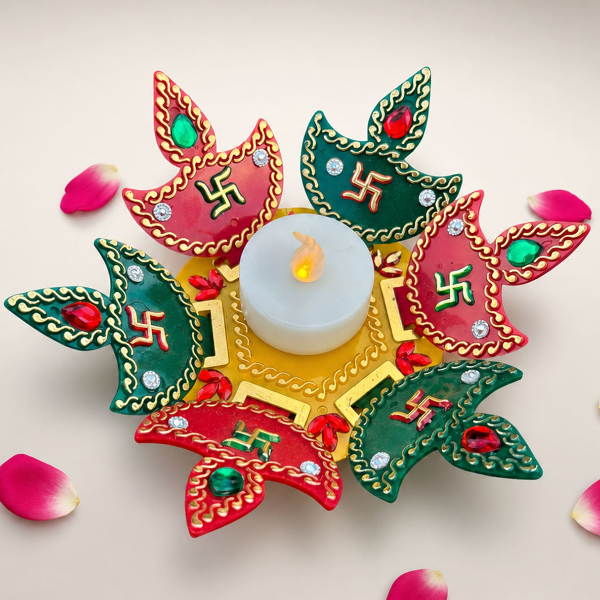 Rangoli diya set featuring a decorative symmetrical holder with red and green petals gold trim swastika symbols and led candle