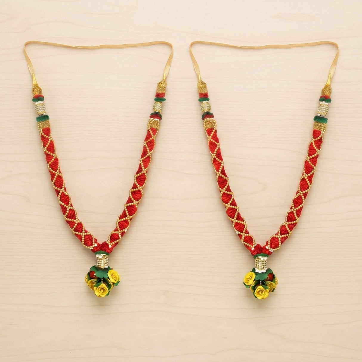 Red and gold woven idol mala necklace with green accents and yellow floral satin pendant for pooja and temple decor