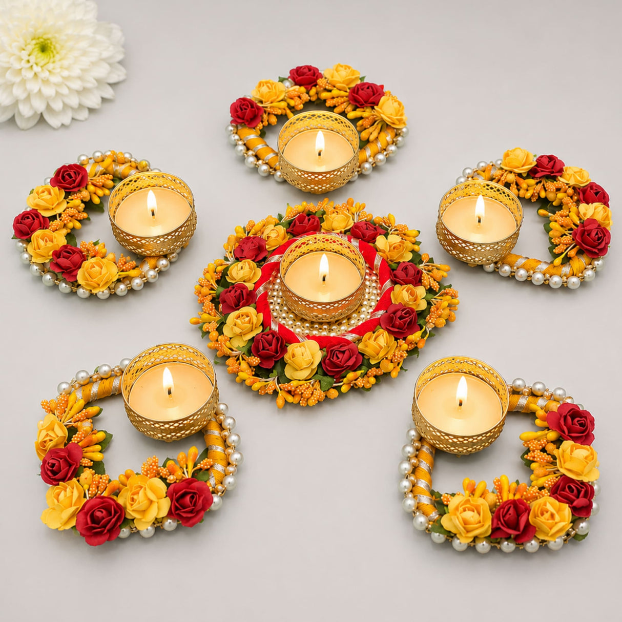 Golden floral rose tealight rangoli candle holders decorated with red and yellow artificial roses pearl beads and lace for festive decor