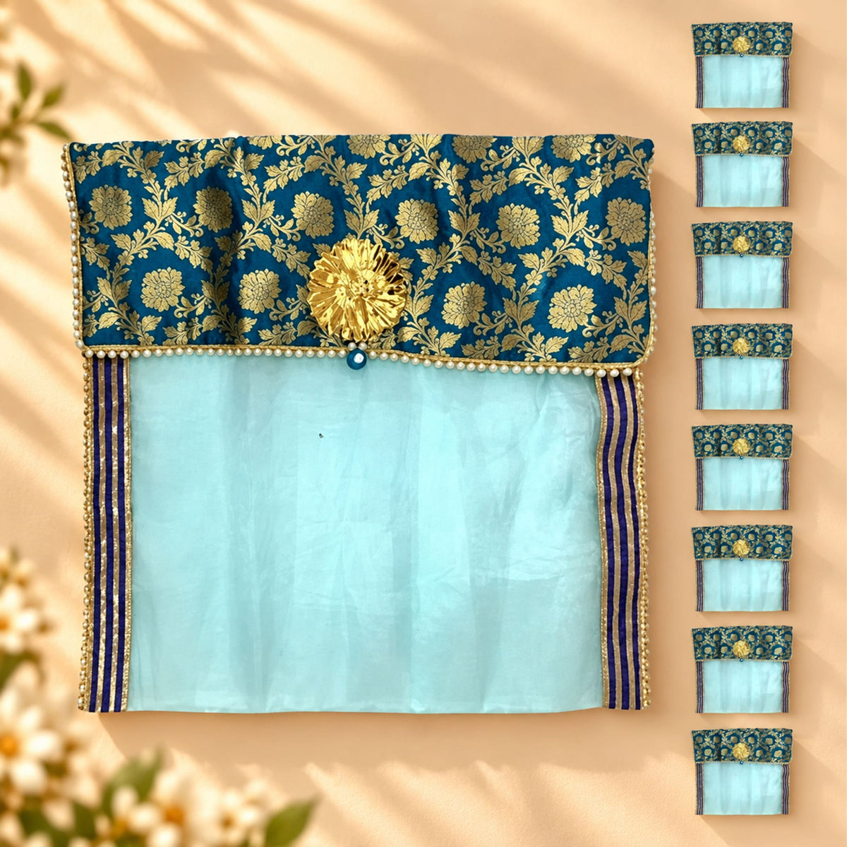 Elegant teal and gold embroidered fabric saree cover with central golden floral embellishment for wardrobe storage