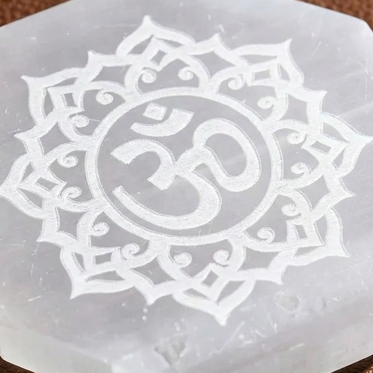 Selenite charging plate with translucent hexagonal shape and white lotus om design for crystal healing and decor