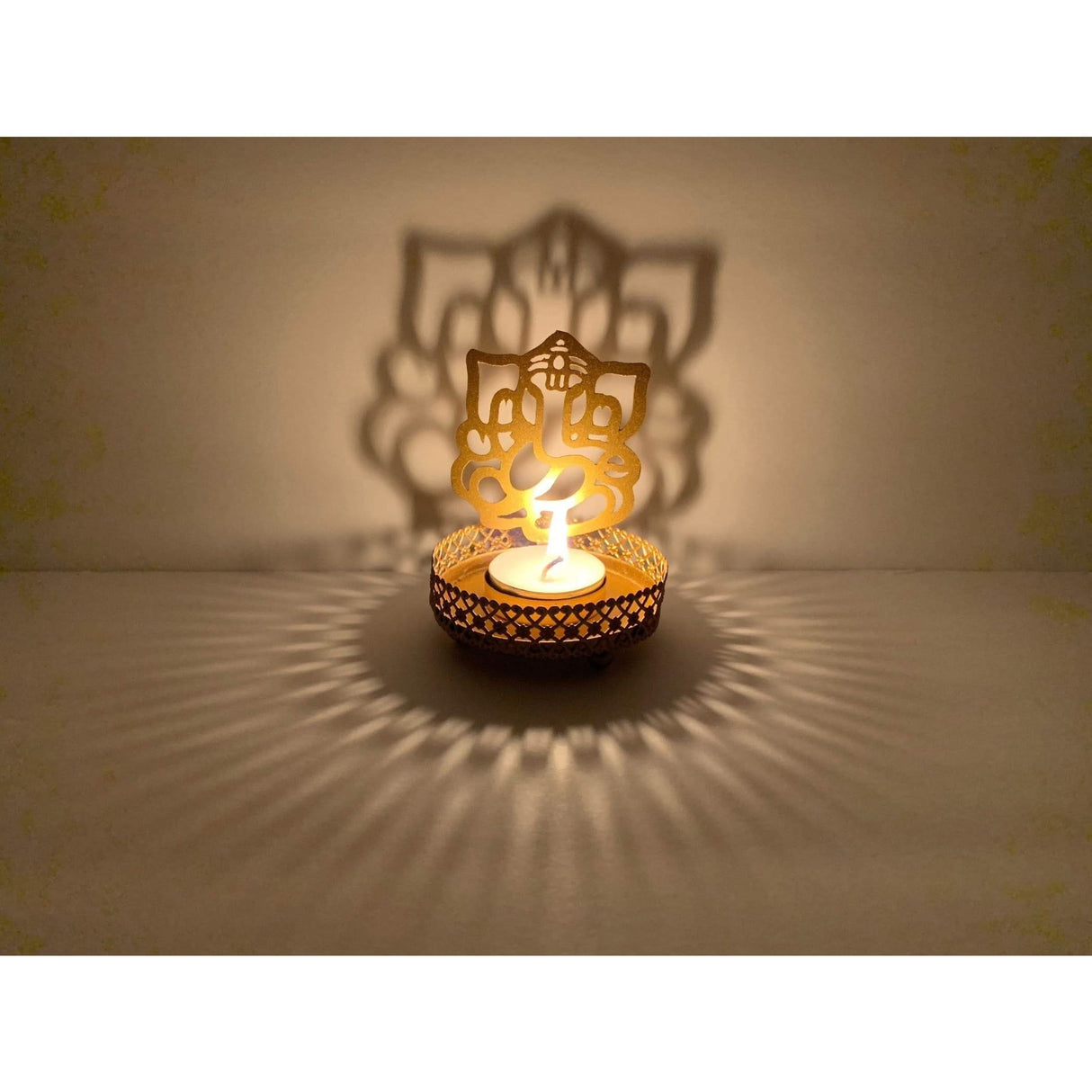 Decorative Ganesha-shaped tea light holder casting intricate shadows for Diwali and festive occasions